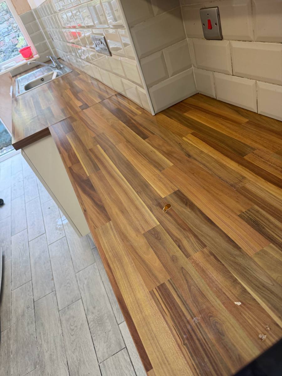 Caravan kitchen with a worn wood-effect worktop, before