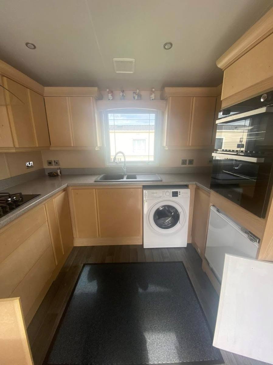 Caravan kitchen doors with the vinyl wrap peeled off, leaving bare MDF, before