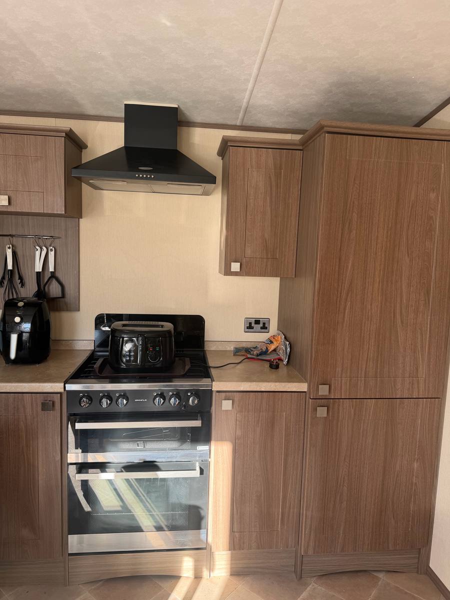 Wood-effect cupboards either side of a range cooker, before