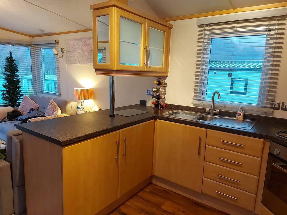 Beech-effect kitchen units with glazed wall cabinets, before