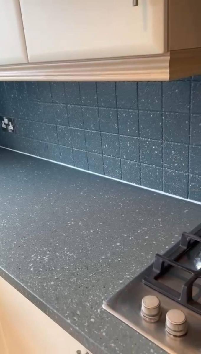 The tiles refinished and the worktop done in blue speckled Spray Granite