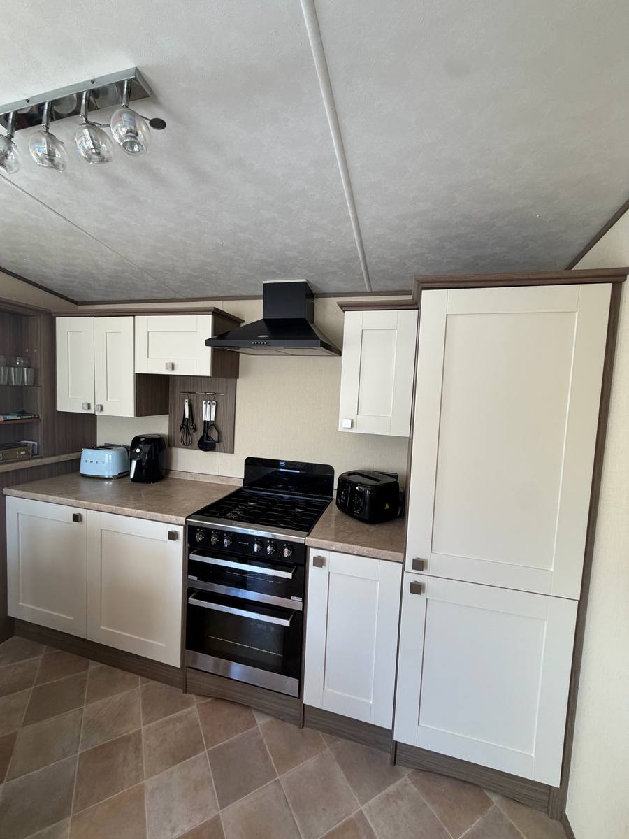 The same kitchen after, with doors painted cream in a shaker style