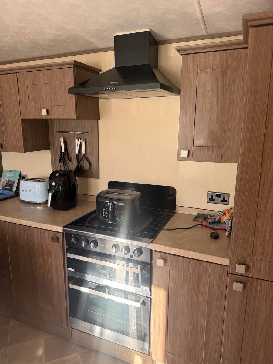 Caravan kitchen with dark wood-effect doors, before